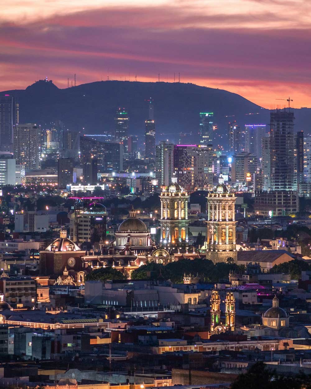 Foto de la Ciudad de Puebla con atardecer de fondo.